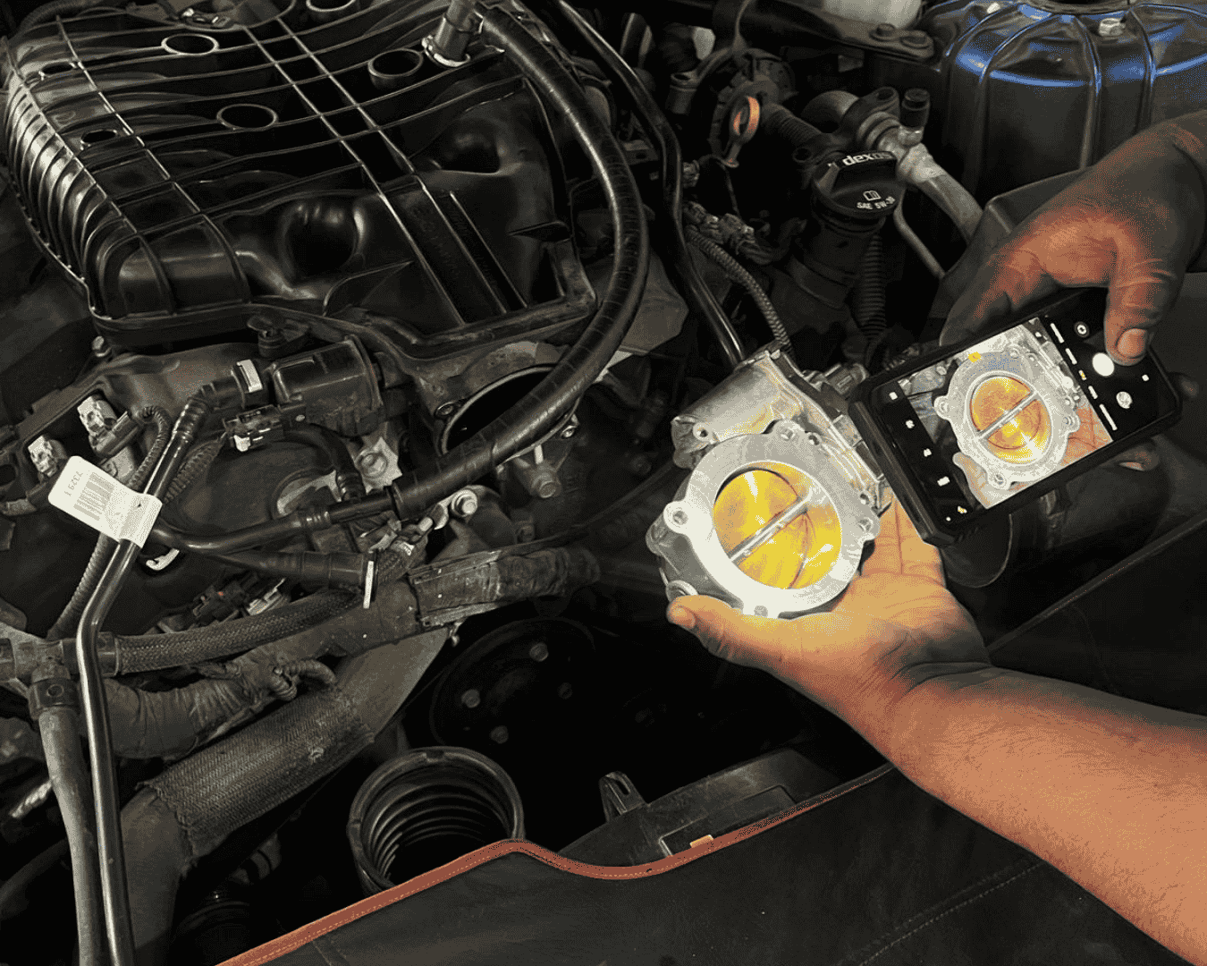 Técnico limpiando un cuerpo de aceleración para restaurar el rendimiento del motor.